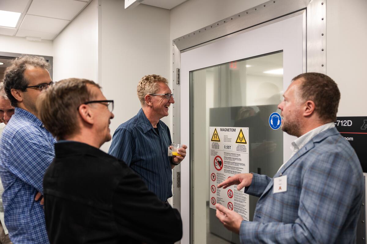 Nixdorf tells attendees about the MRI machine while they view it through protected windows