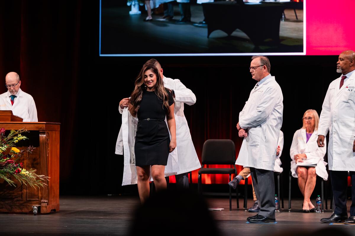 Student receives her white coat onstage