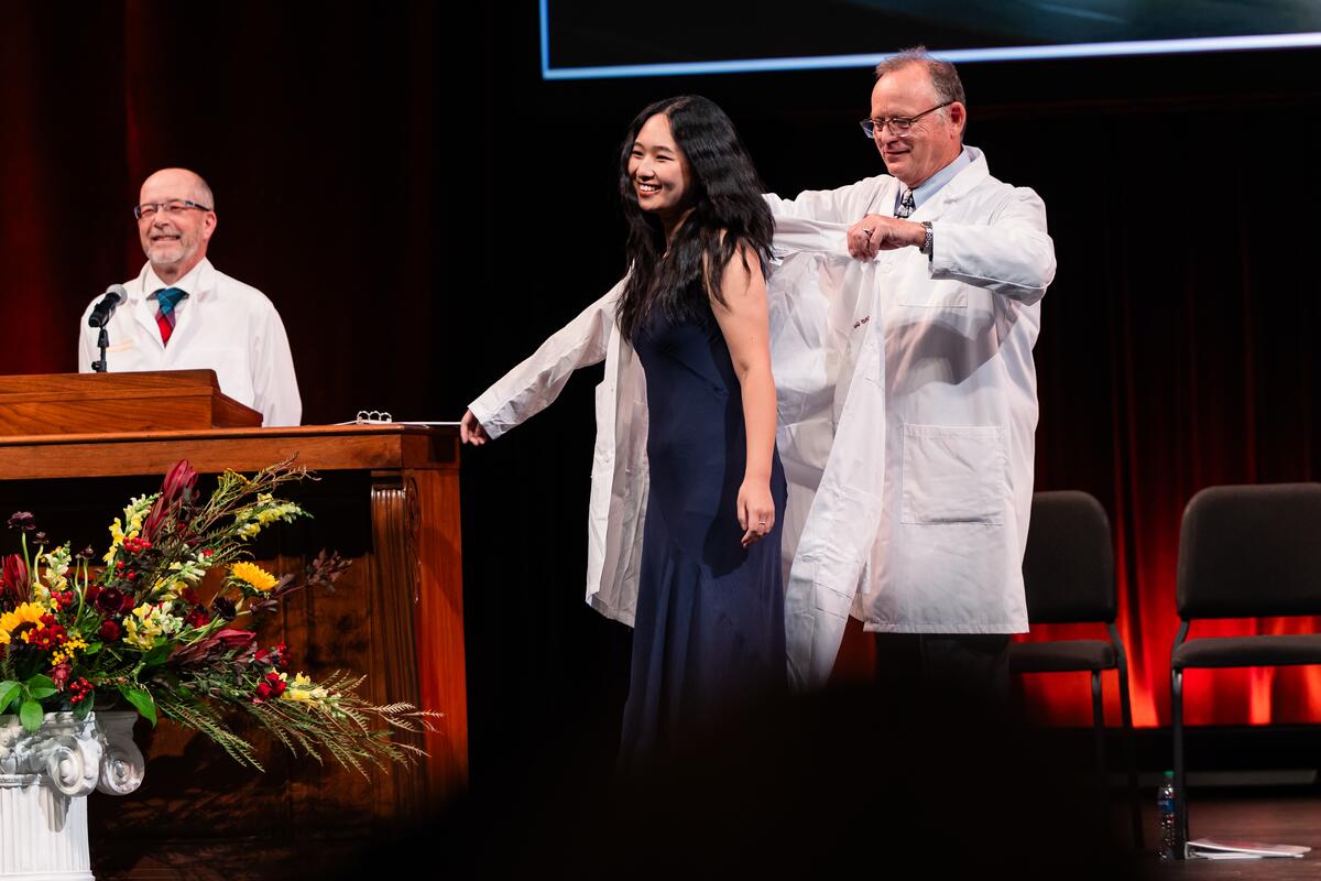 Student receives her white coat onstage