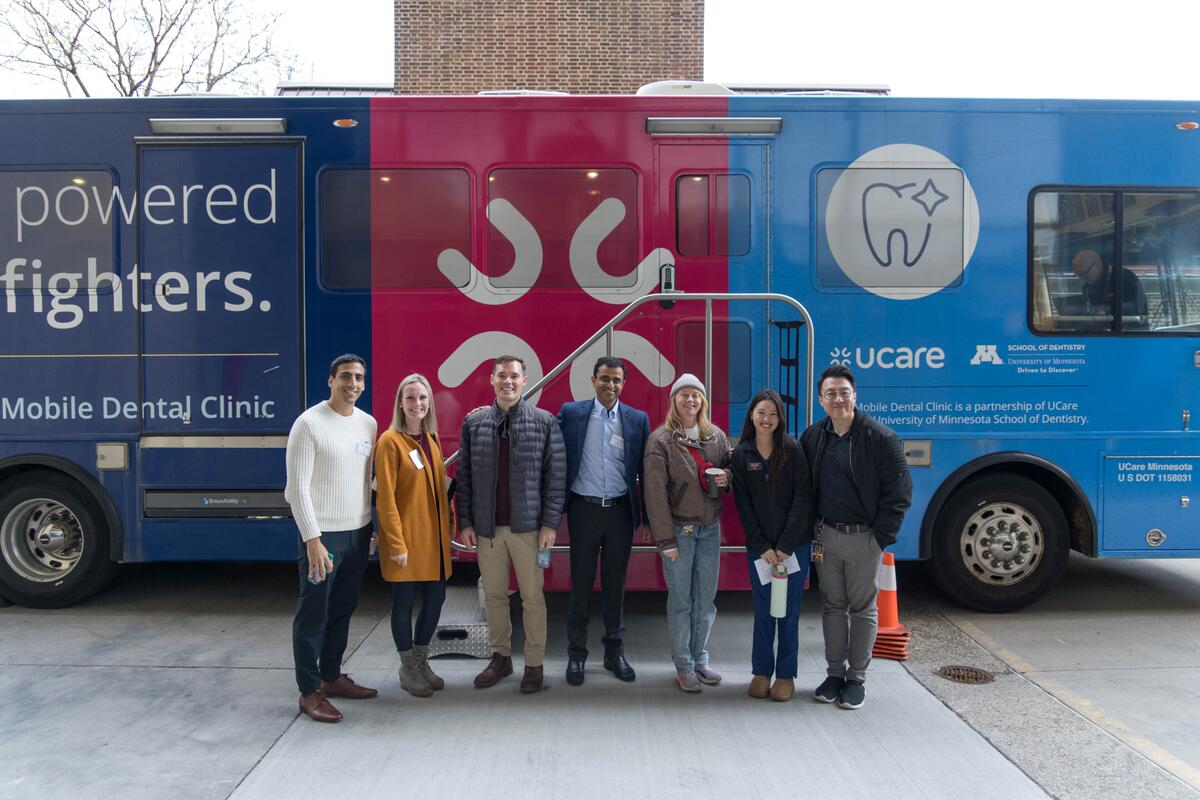 Guests at alumni weekend standing outside mobile dental clinic.