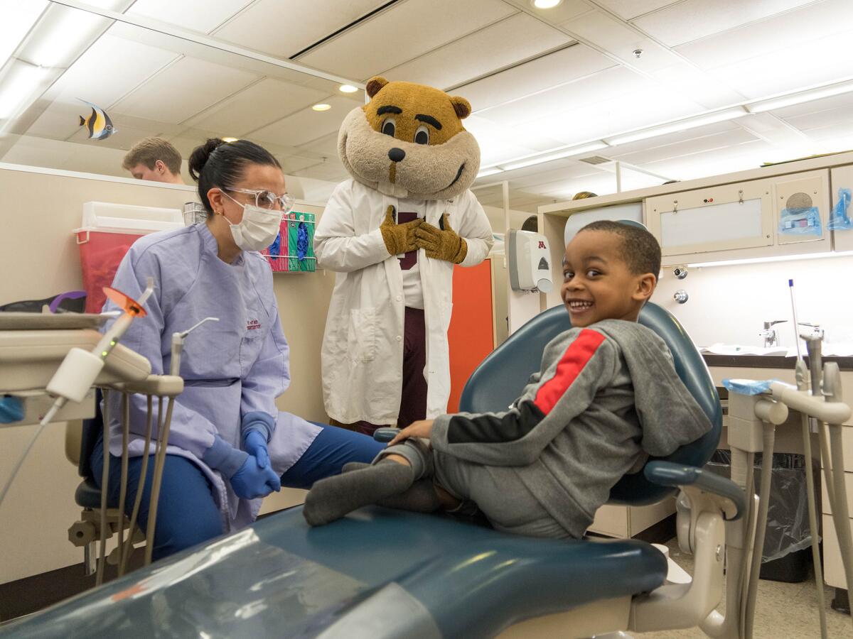 Goldy and patient smiling at event.