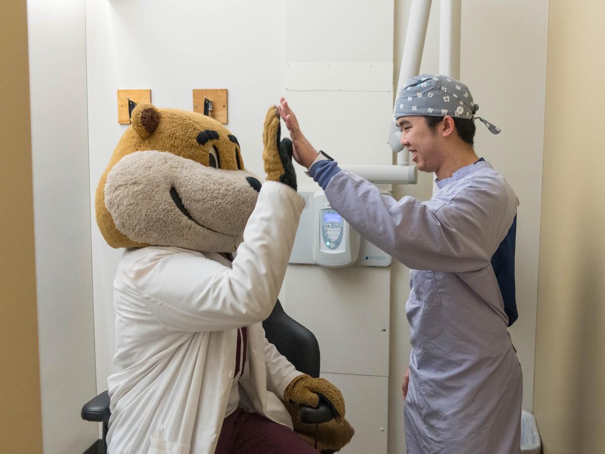 Goldy highfiving resident.