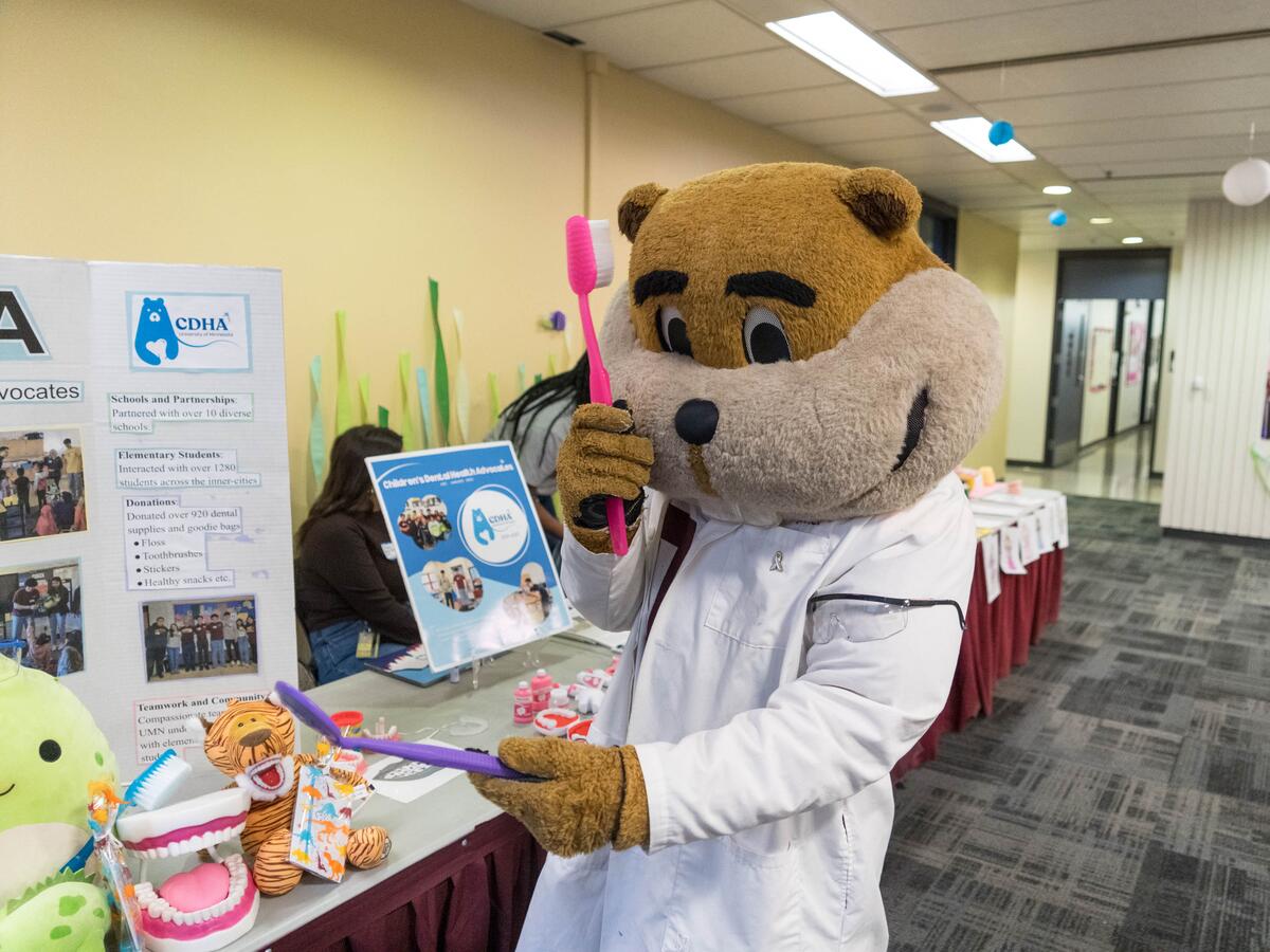 Goldy with big tooth brush at event.