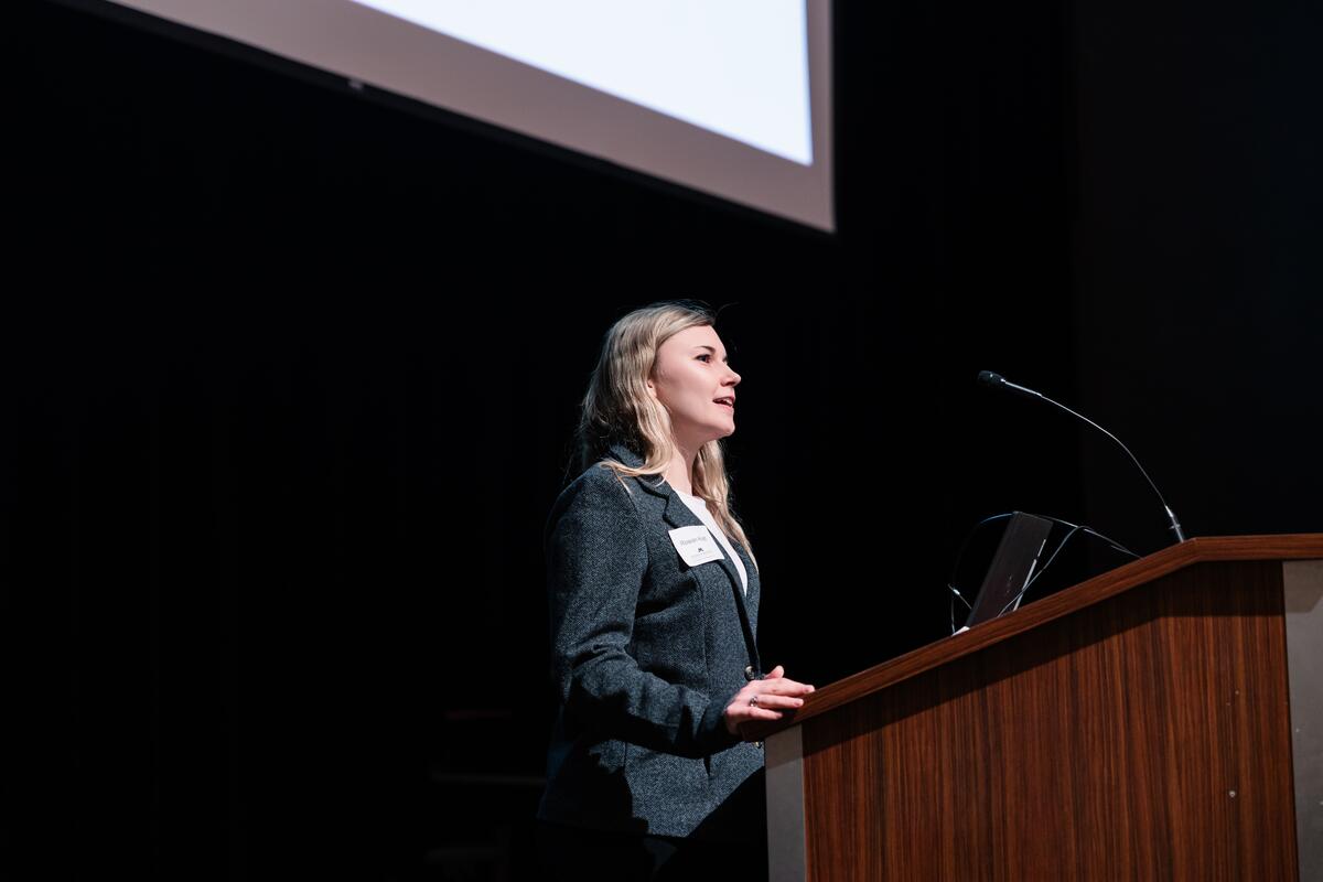 A student researcher speaks from the podium