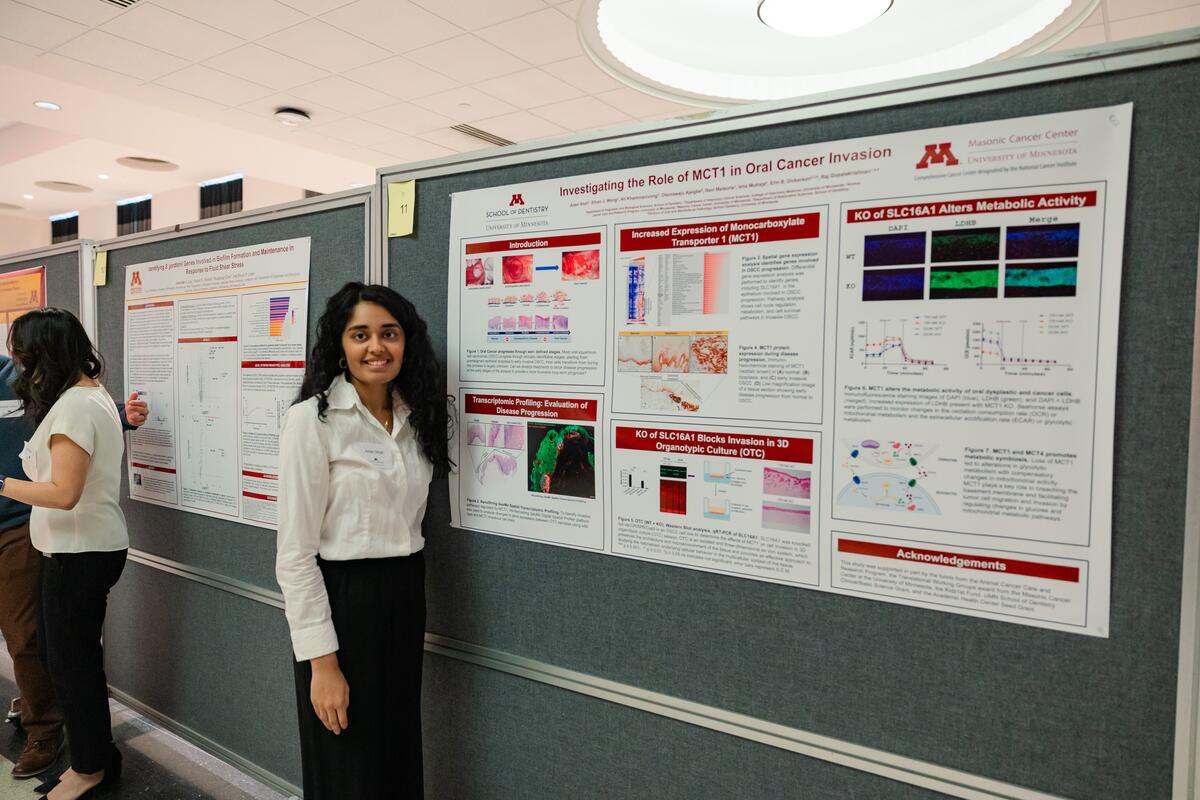 A student poses with her research poster