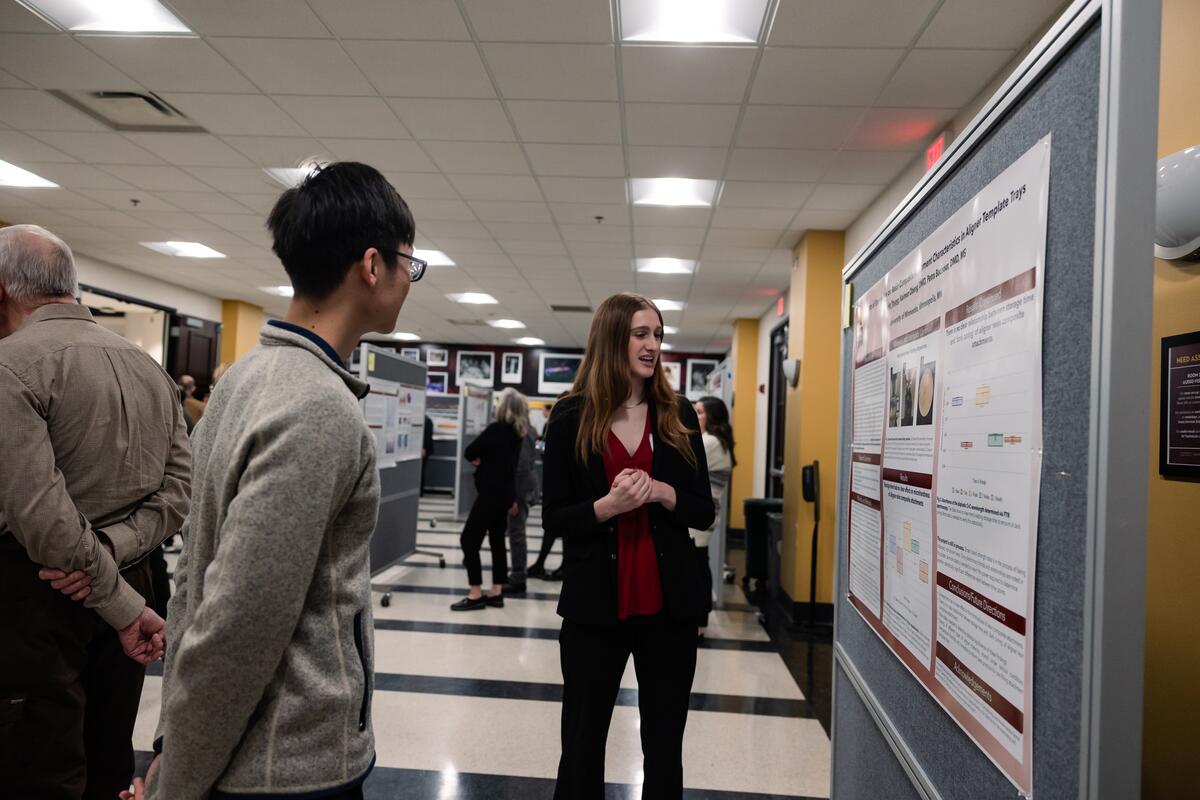 A student presents her research poster