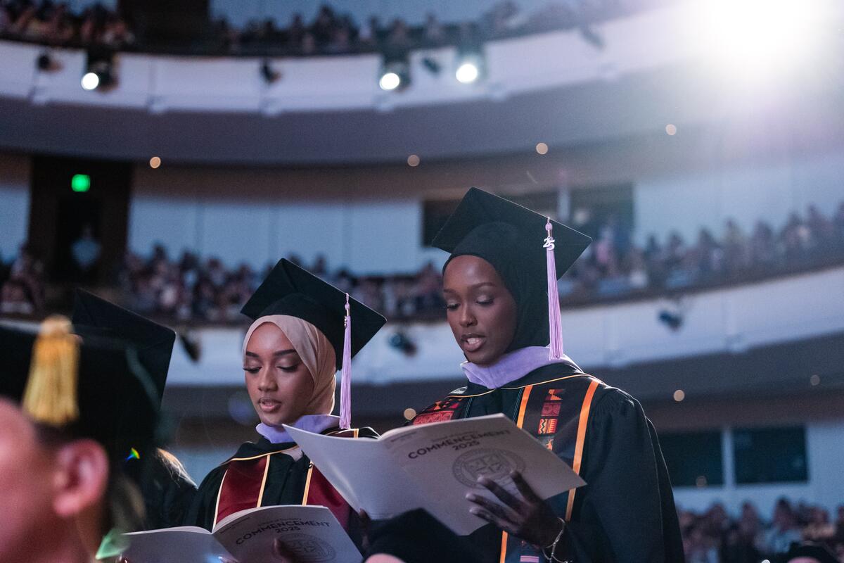 Graduates reading commencement directory