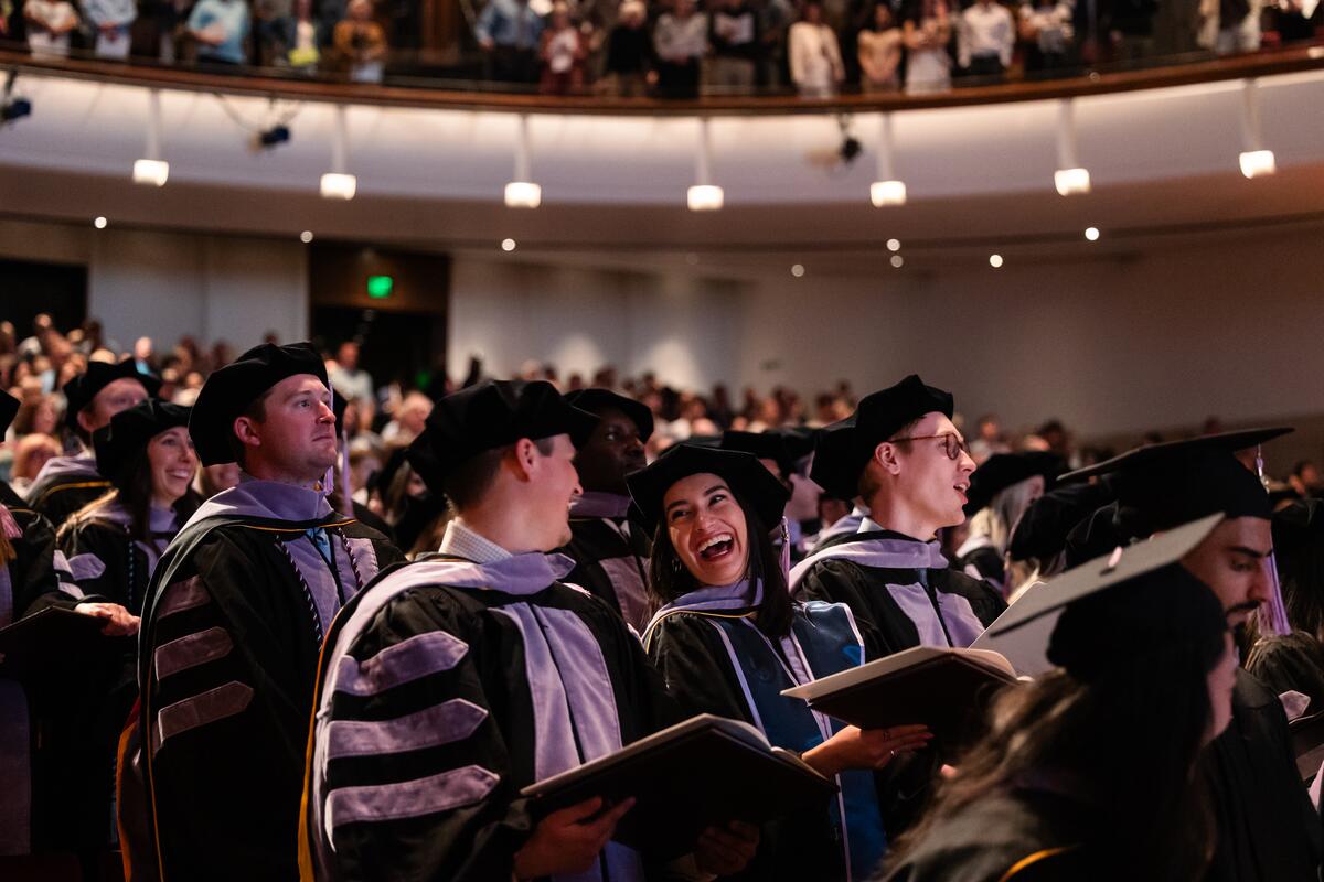 Graduates laughing at commencement