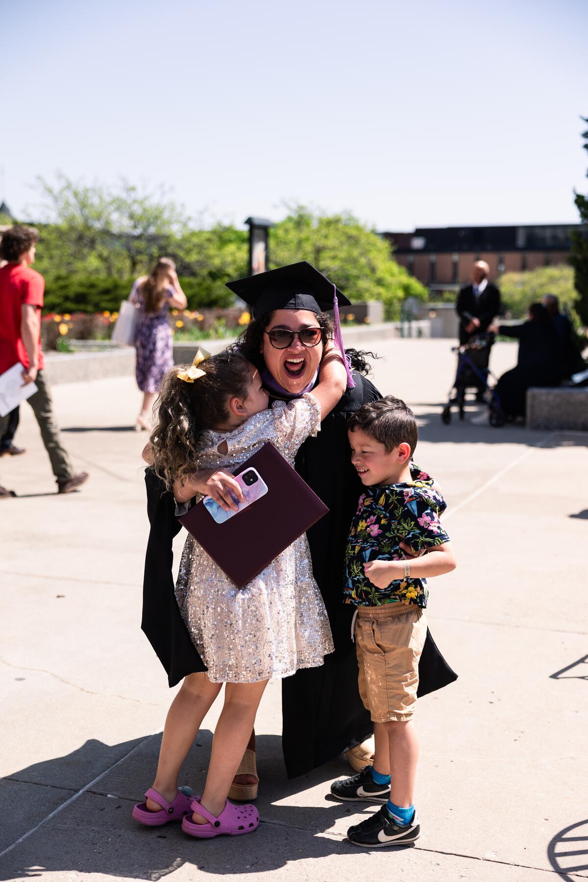 Graduate outside at commencement with children