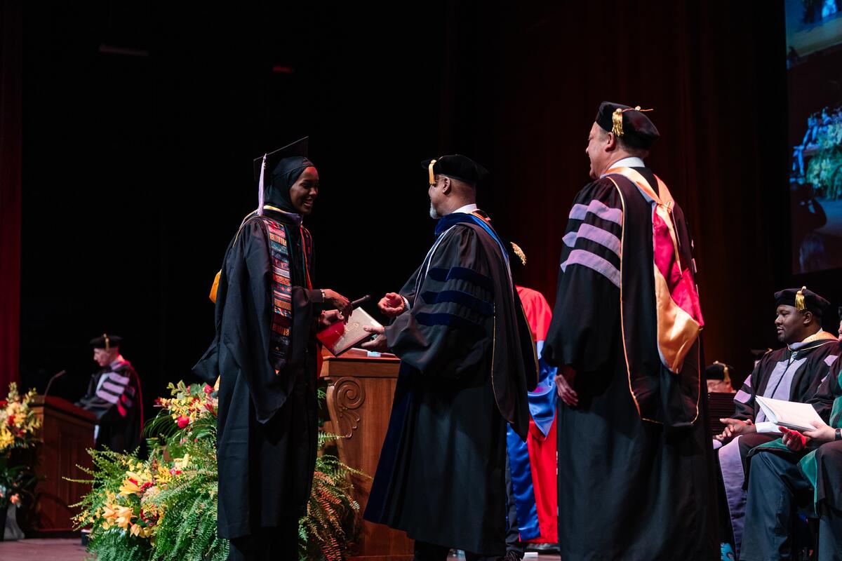 Dean Mays and graduate on stage at commencement