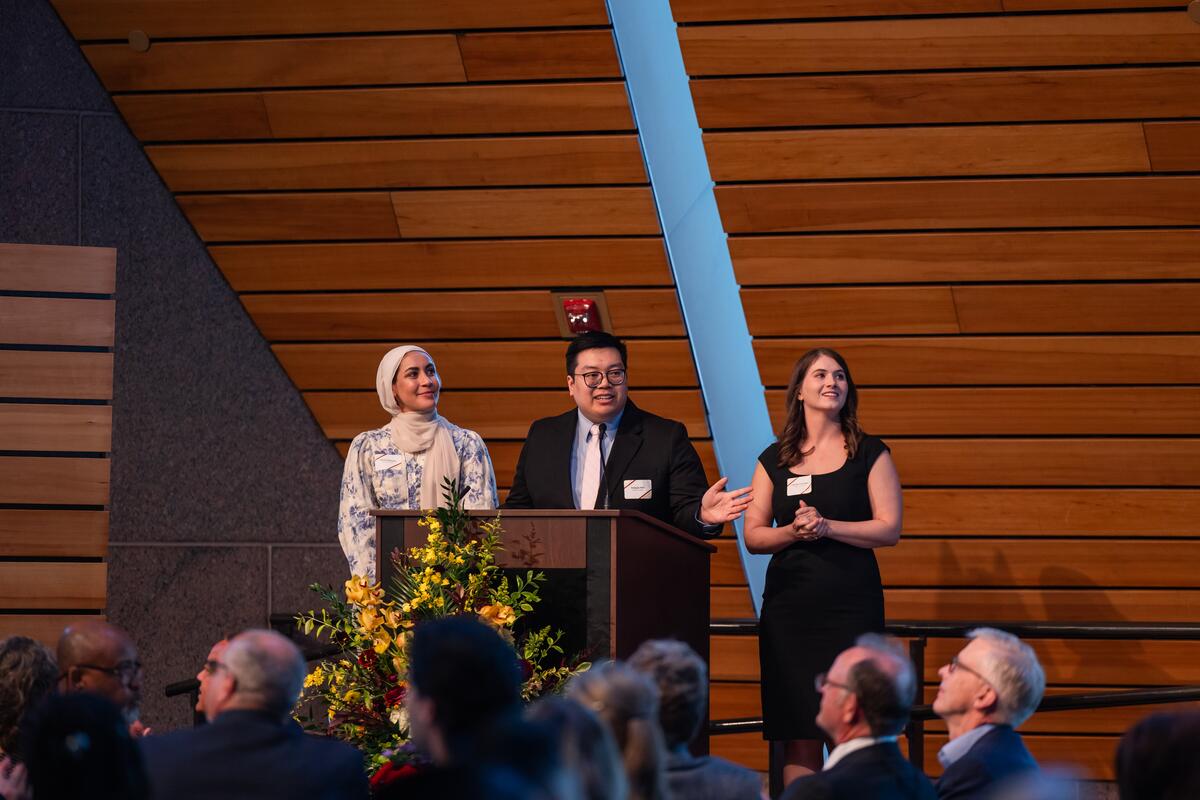DDS class officers Fatma Diefalla, Sung-Ju Kim and Cecilia Lovinger present onstage