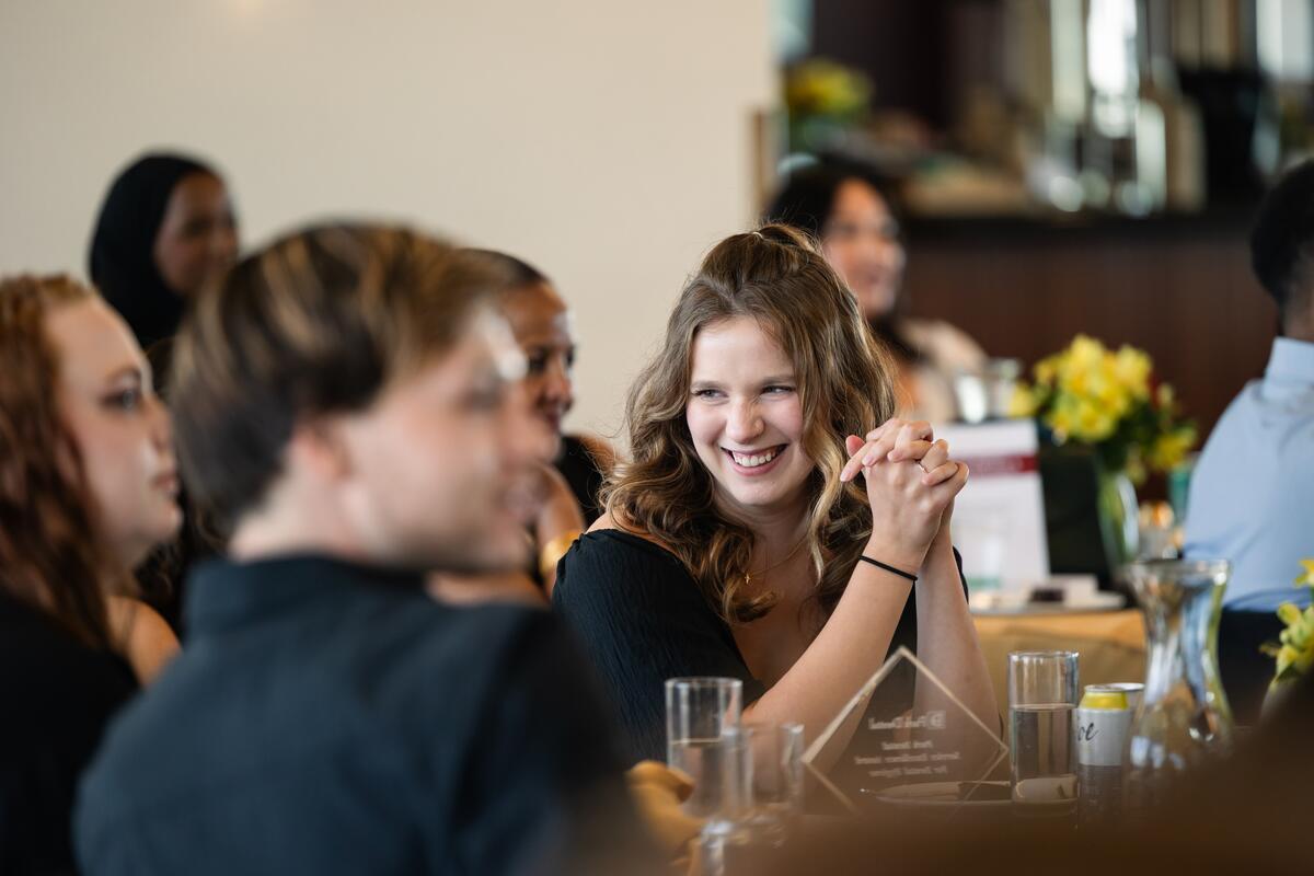 Award recipient smiles at their table mates