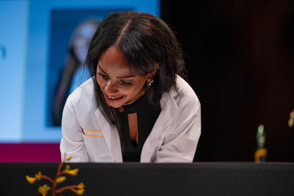 a white coat ceremony honoree signs the class code of ethics