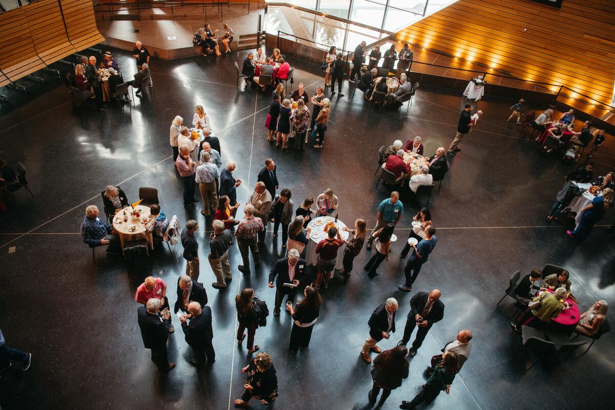 a bird's eye view of alumni weekend attendees mingling around tables at McNamara Alumni Center