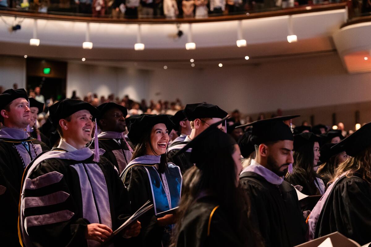 2025 DDS graduates smile in the audience at commencement