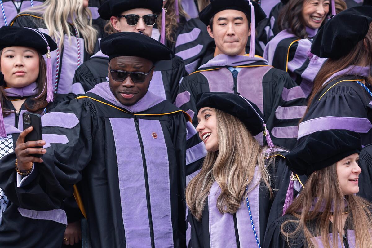 Students take a selfie in regalia