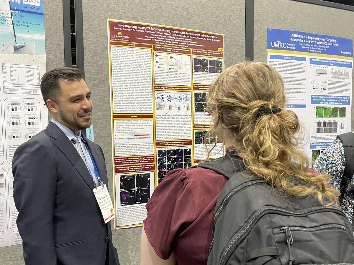 an oral biology student presents a poster