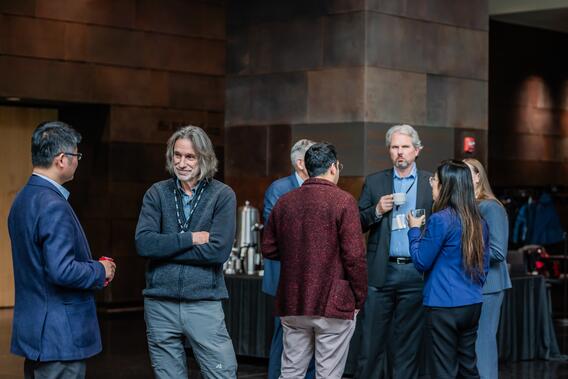 Attendees talk during a break in the symposium