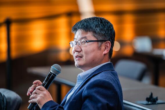 Attendee asks a question using a microphone in the audience