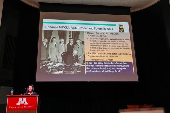 D'Souza speaks with a powerpoint behind her