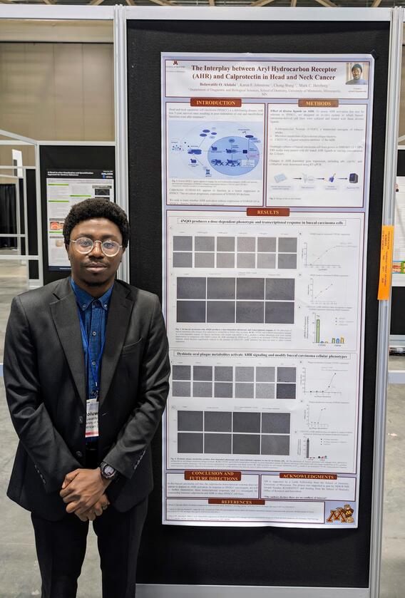 Boluwatife Olu Afolabi standing by research poster