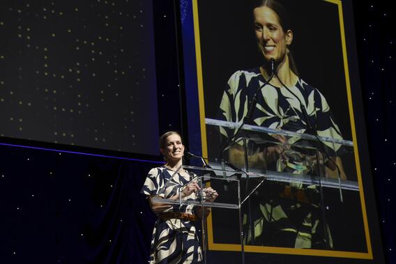 Katie Divine speaks from a podium