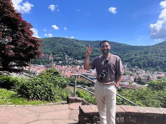 Isaac Tade makes a peace sign atop a scenic vista in Heidelberg