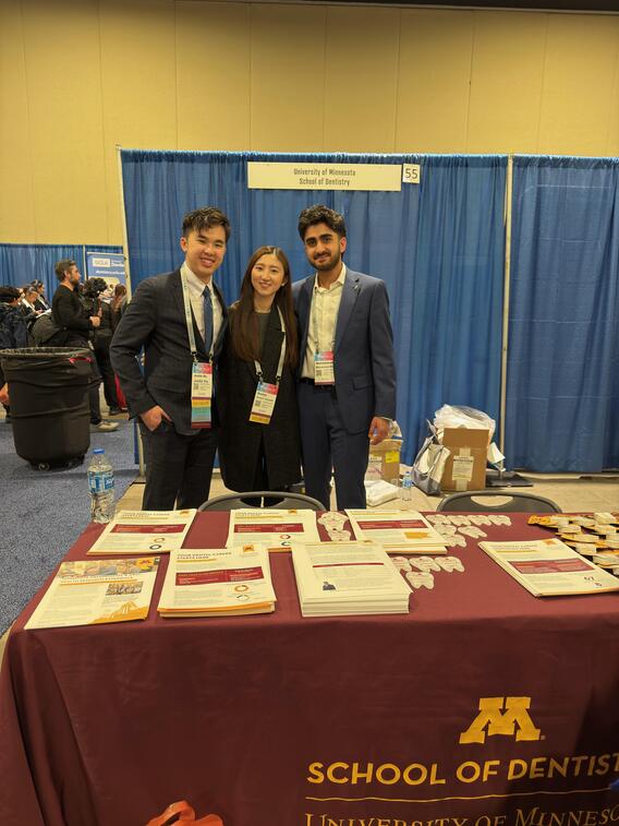 Students pose at the School of Dentistry's booth at ADEA