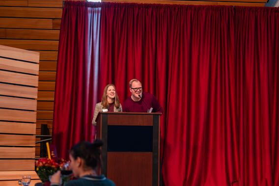 Noelle McComb Simonson and Robert Springer talk and smile onstage
