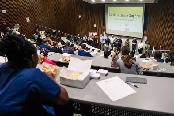 Employers introduce themselves to a lecture hall of current students at the Gophers Hiring Gophers job fair
