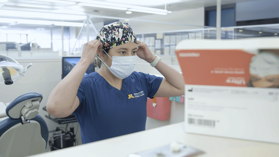 Jessie Walsh dons a mask and prepares for a patient