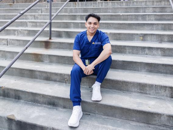 Elvis Idrovo Mejia sits on the steps in front of Moos Tower