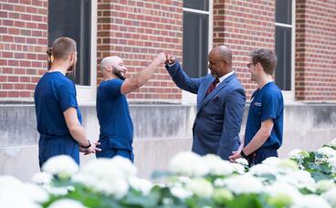 Jose Gigato Gonzales and Dean Keith mays share a fist bump by Moos Tower