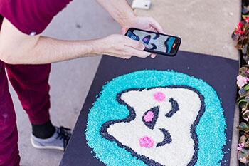 Tim Bitner takes a photo of his rice creation of a tooth for Tiktok