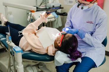Patient learns how to brush her teeth from dental provider