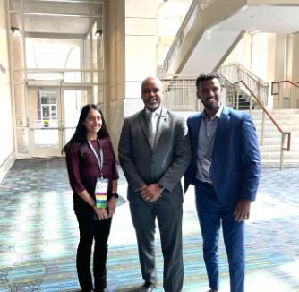 Dean Mays poses with two students for a photo