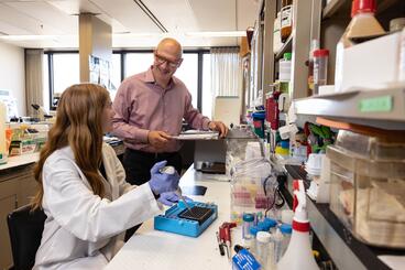 two reseachers in the Costalonga Lab working with fluids and pipets