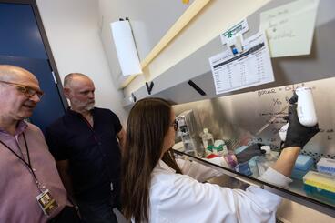 A researcher moving fluids in the Costalonga Lab