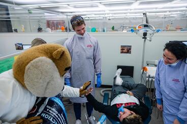 Goldy gives a child a high five