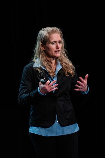 Julie Olson presents in front of a black background