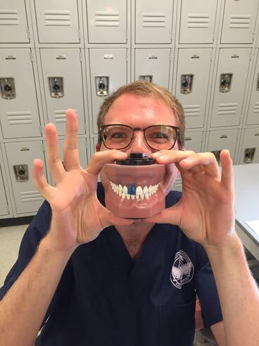Springer as a student, holds up a mouth model