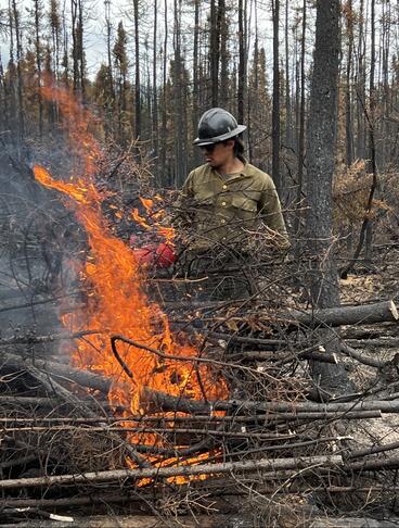 Isaac Armstrong fighting fire in forest. 