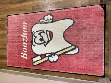Welcome mat says "boozhoo" with a photo of a tooth and toothbrush
