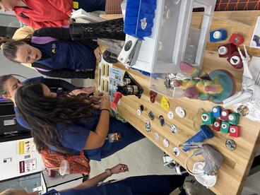 Students use the button maker in the Makerspace