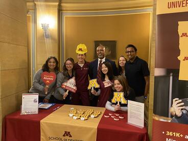 Mays and students pose at a University of Minnesota booth