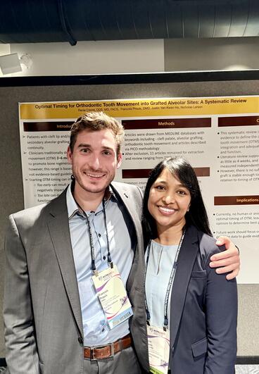 A student poses with Renie Daniel in front of his poster
