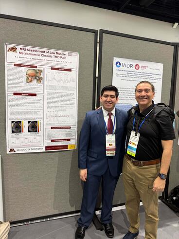 Johan Alfaro Carballo and Estephan Moana-Filho pose in front of Alfaro's poster