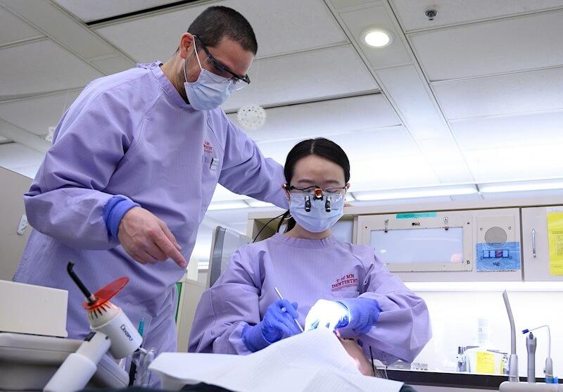 Two dentists providing care to a patient