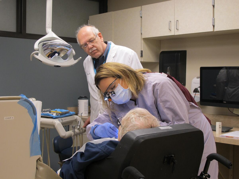 Dr. Stephen Shuman supervises a dental hygiene student providing care to an older dental patient