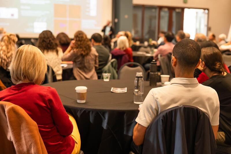faculty members attend a talk at a conference